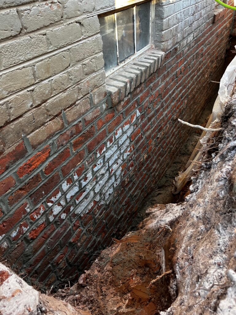 Brick foundation repair along the base of a home's wall in Greater Boston.