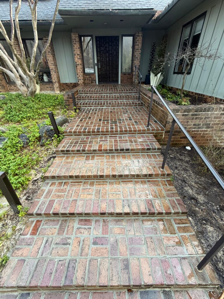 Stone entrance steps and walkway leading to the front door of an older Greater Boston home in winter.