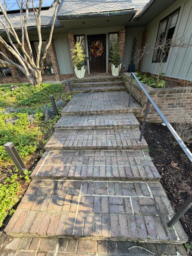 Completed stone steps and walkway at a Greater Boston home's front entrance after masonry work.