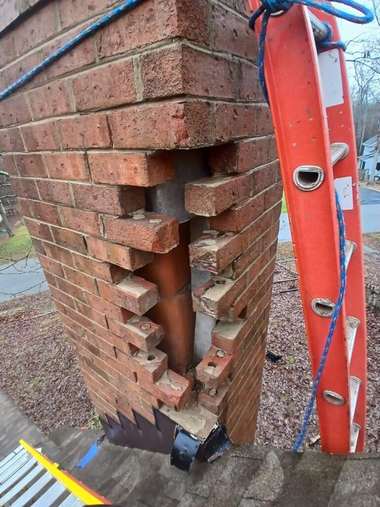Spalling and missing brick on a deteriorating chimney in Greater Boston, before repair.