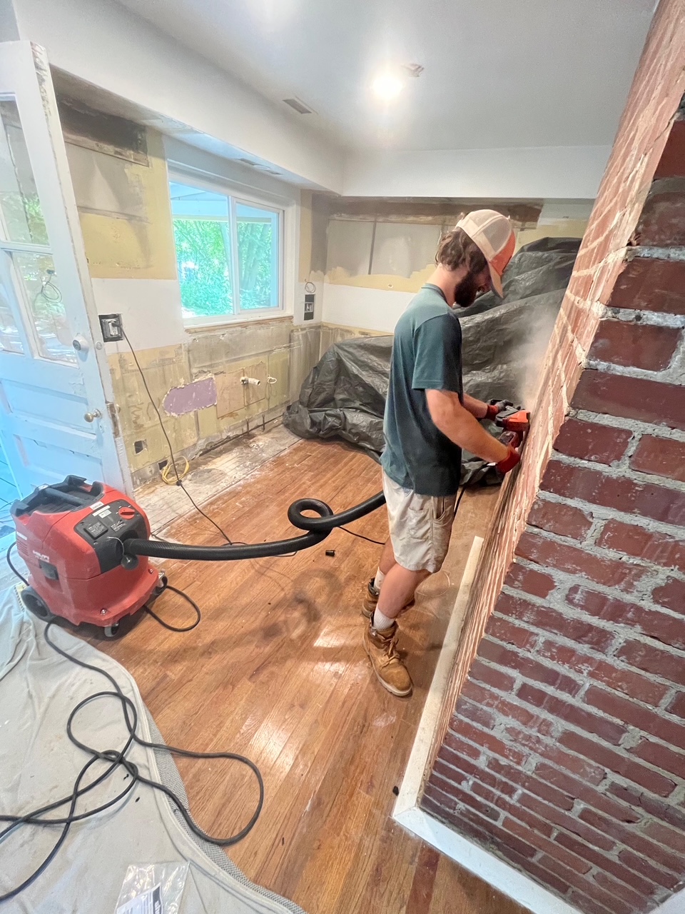 A Three Hills Masonry & Foundations mason repairing an interior brick chimney column in a Greater Boston home.
