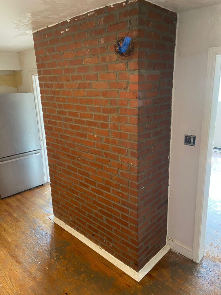 Exposed brick masonry on an interior chimney column in a Greater Boston home.