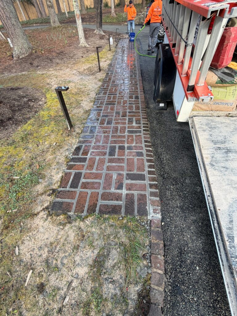 A brick walkway installation in progress, laid on a prepared base