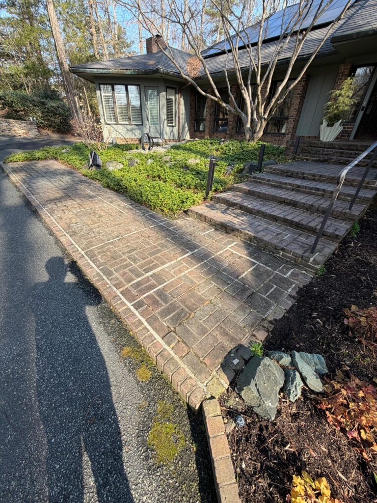 A finished brick walkway and masonry steps along the front of a Greater Boston home