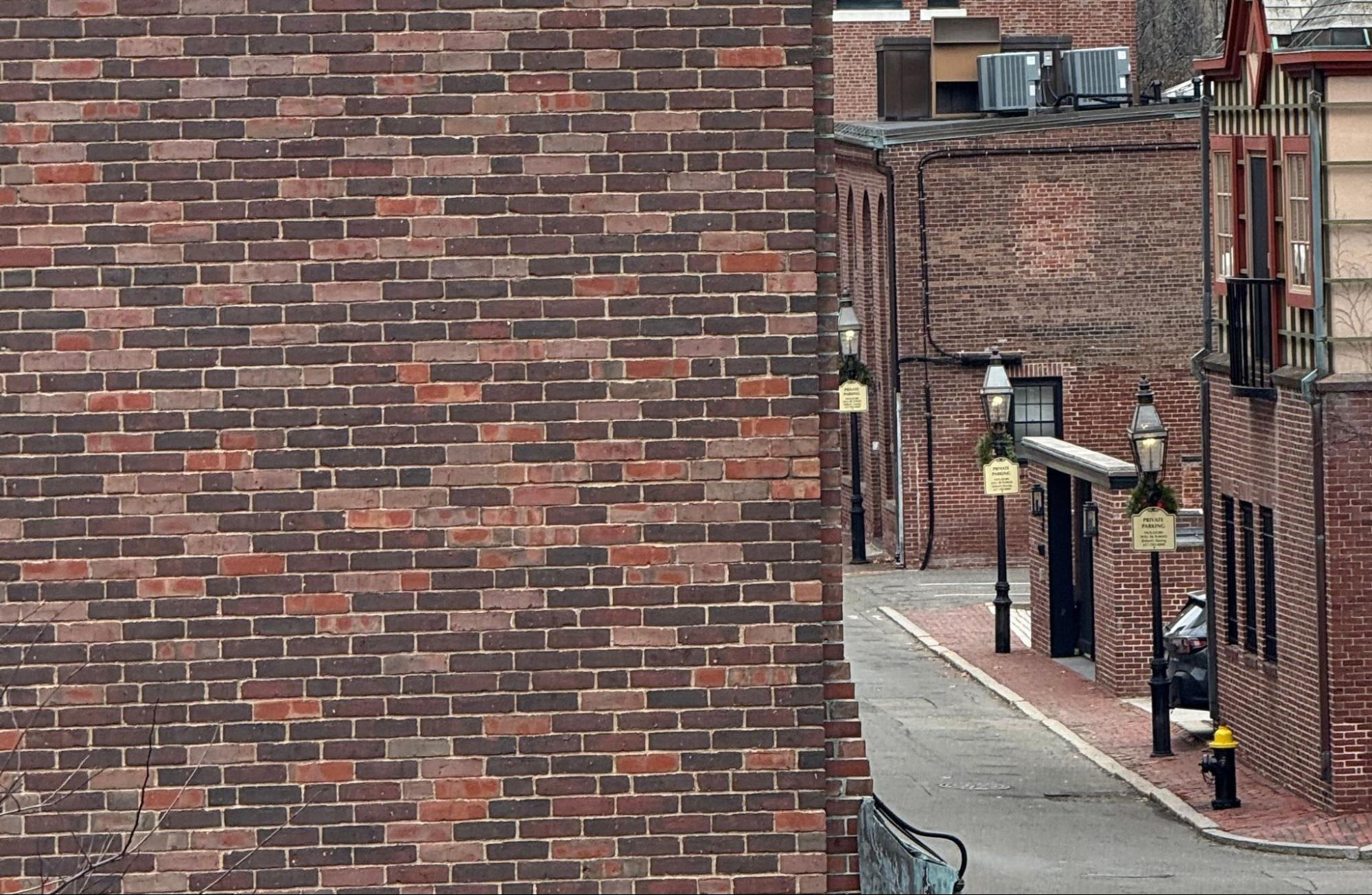 Older brick buildings along a Greater Boston street where repointing old brick is common.