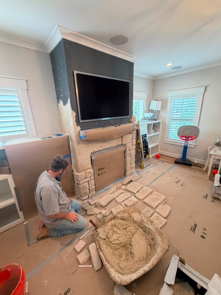 Mason with Three Hills Masonry & Foundations setting stone around a fireplace in a Greater Boston home.