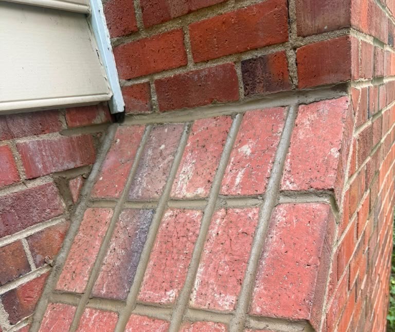 Fresh mortar joints packed into brickwork during a chimney repointing on an older home.